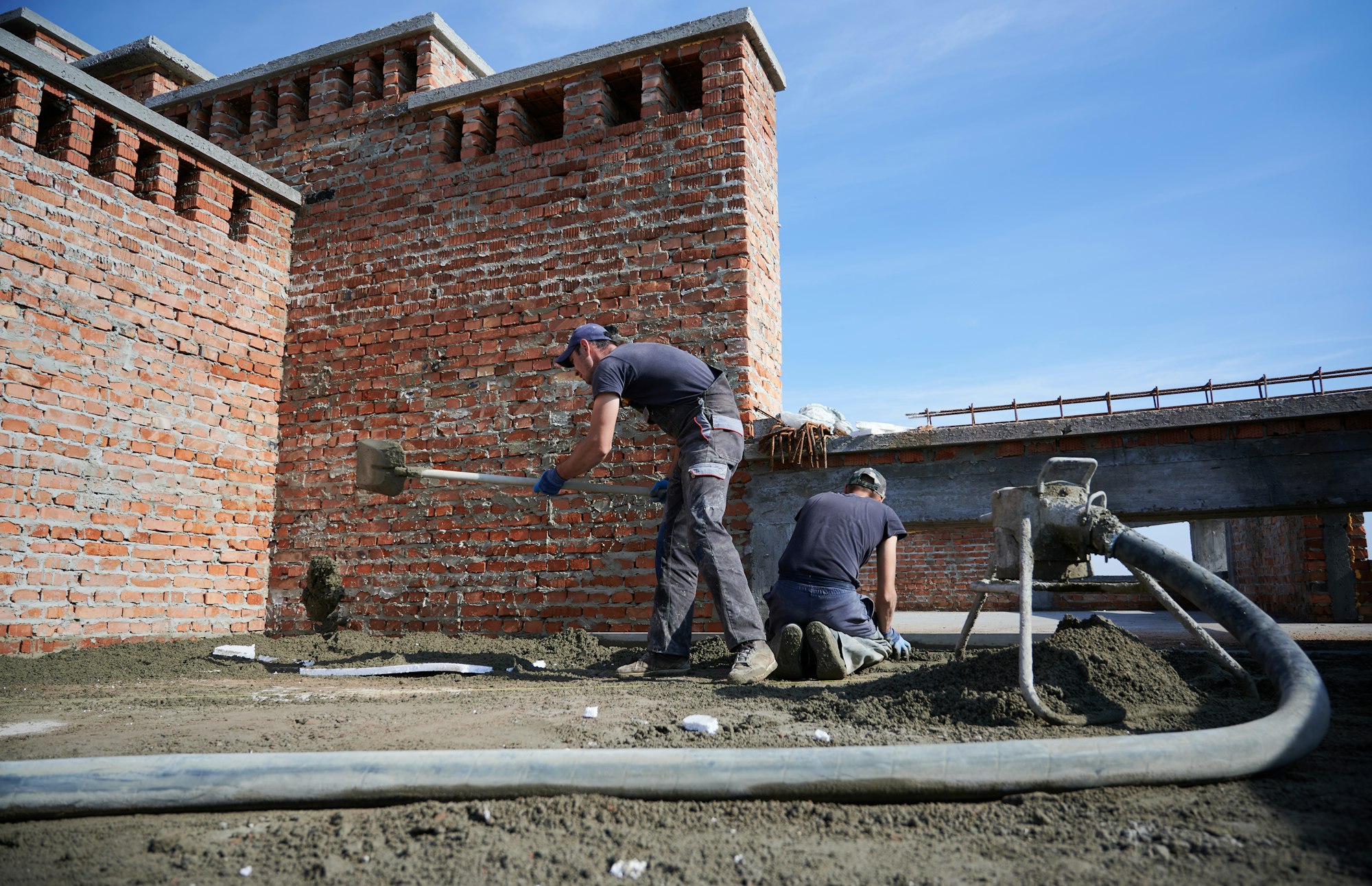 Process of laying semi-dry screed on construction site outside.